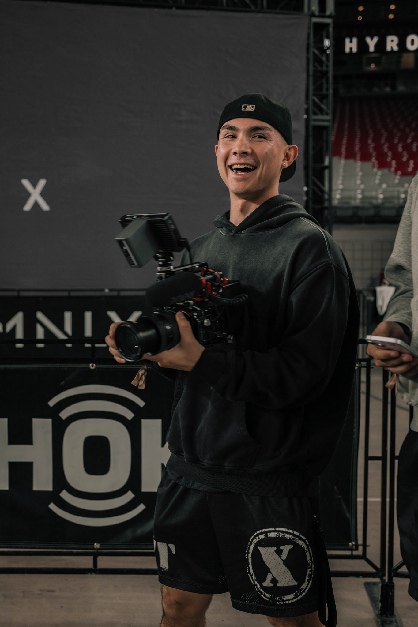 Isaac smiling on set while holding a cinema camera