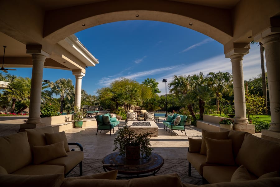 Covered outdoor living space opening onto a pool